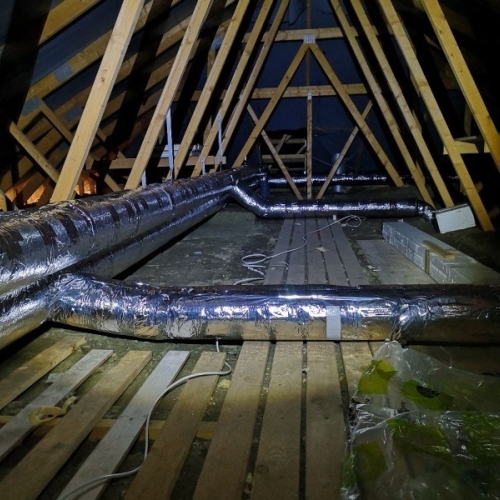 Ventilationssystem på loft med rørføring og isolering til boliger.