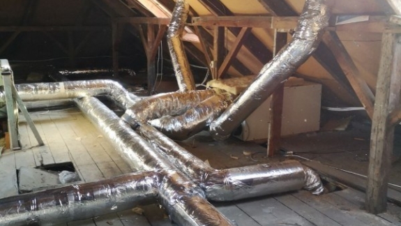 Isolerede ventilationsrør installeret på loft til villaventilation og aircondition.