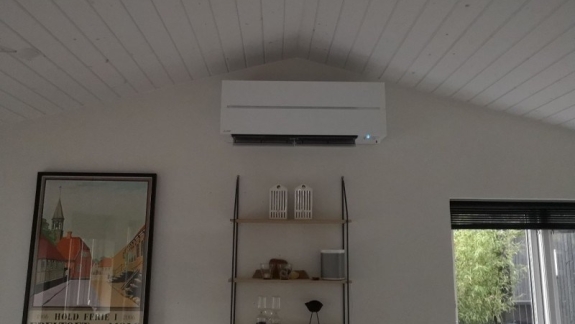 Indendørs varmepumpe på hvid væg under loftspids.